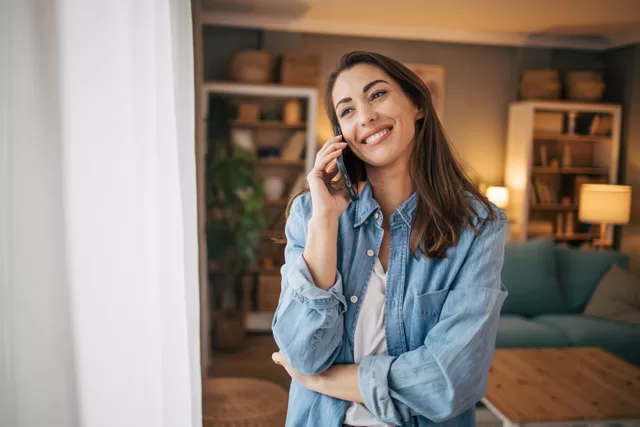 woman smiling and speaking on the phone